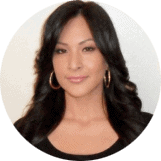Close-up of a woman with dark hair wearing a black top.