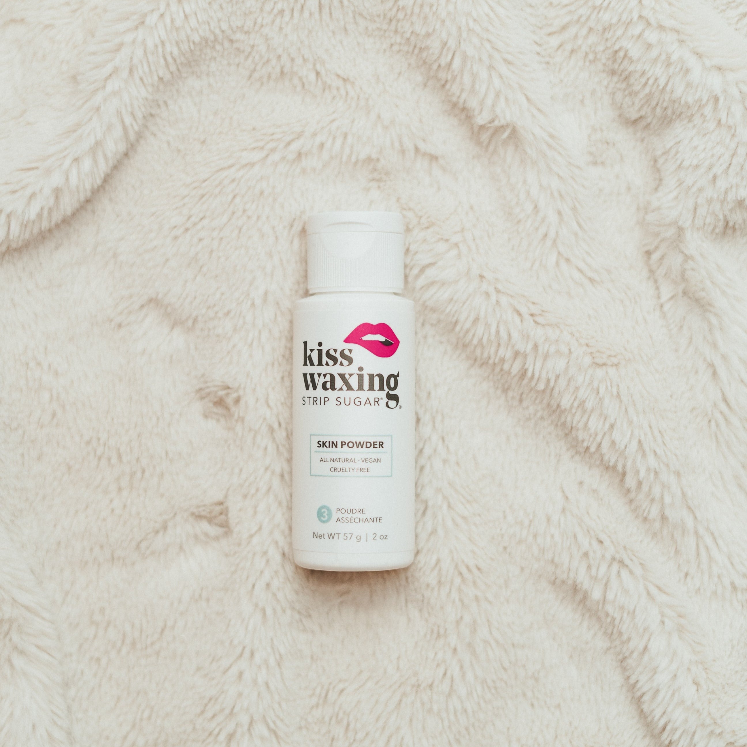 Kiss Waxing skin powder bottle on a textured beige surface
